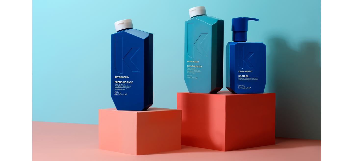 REPAIR-ME.RINSE, REPAIR-ME.WASH, in blue bottles on red and orange geometric blocks against a teal and pink background.